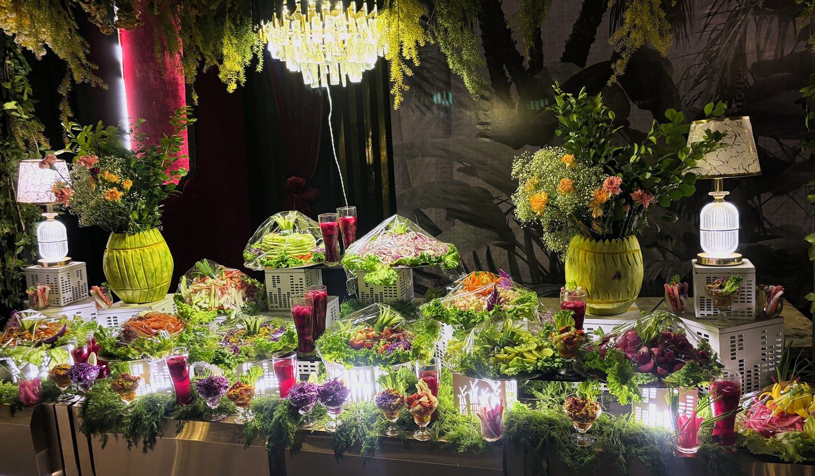 Salad and greens display under a chandelier