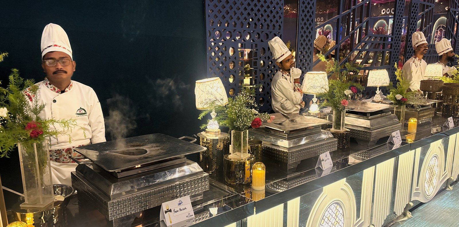 Chef at a lit live counter, steam rising