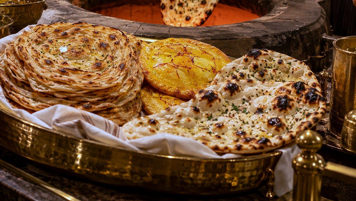 Illustration of a platter of laccha paratha, sheermal and naan
